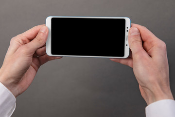 Man's hands holding mobile phone