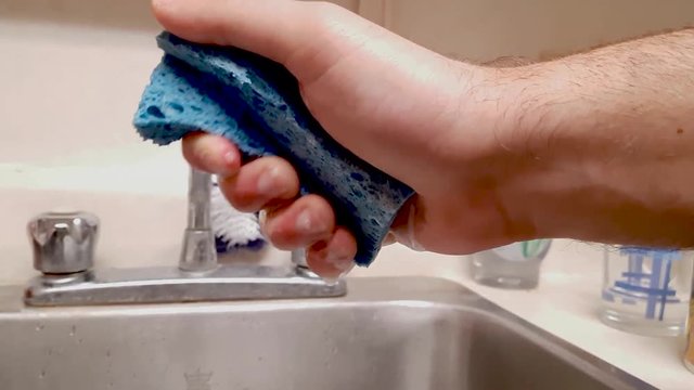 Man squeezing water out of sponge