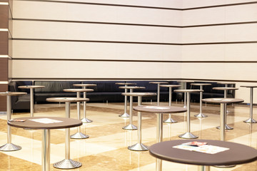  Empty round tables in the hall. Striped walls and marble floor