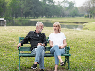 Old couple talk in a park on a sunny day. Senior couple relax in the forest spring summer time. free time, lifestyle retirement grandparents concept