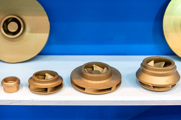 Industrial casting parts vane pump or propeller blades gold color or brass on table