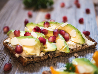 Delicious and healthy avocado toast with pomegranate, bell pepper and almond