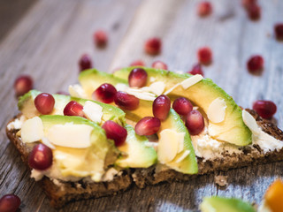 Delicious and healthy avocado toast with pomegranate, bell pepper and almond