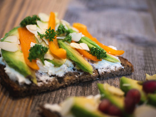 Delicious and healthy avocado toast with pomegranate, bell pepper and almond