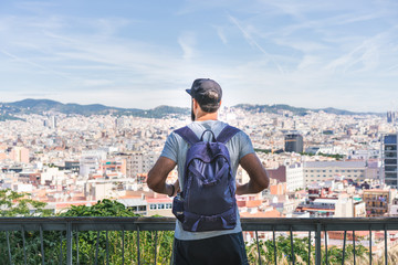 Traveler man looking on a big city, travel and active lifestyle concept.Bearded Tourist Man with backpack enjoy beautiful panoramic view of modern european city