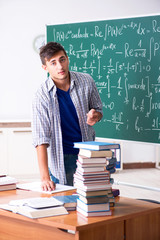 Young male student studying math at school