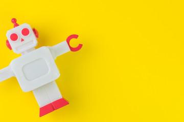 Chatbot or AI Artificial Intelligence or robotic concept, cute vintage look plastic robot on vivid yellow background