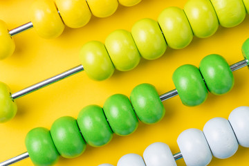 Colorful wooden abacus beads on yellow background, business financial or accounting cost and...