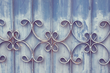 Old wrought iron bars on the gate with grunge and rusty steel  background. Iron Grill Ornamental Flourish Detail Background. The old rusty fence with metallic gate pattern, curved steel background.
