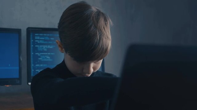 Prodigy Boy Hacker Programmer working on computer in secret data center