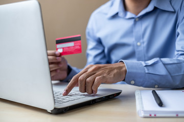 Businessman holding credit card  for online shopping while making orders via the Internet. business, technology, ecommerce and online payment concept