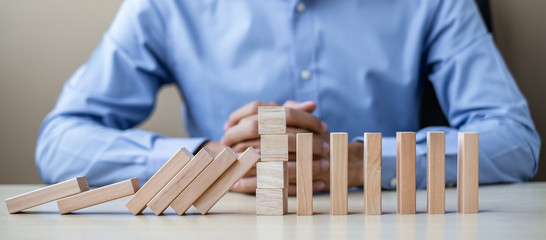 Businessman with wooden Blocks or Dominoes. Business, Risk Management, Solution, Insurance and...