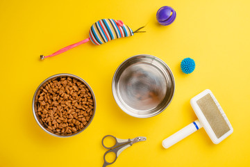Pet, cat, food and accessories of cat life flat lay, on a yellow background. Background for design.