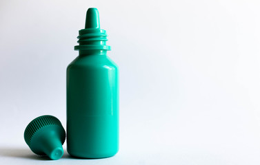Green plastic eye dropper bottle isolated on white background.