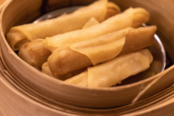 Fried Chinese spring rolls in the wooden basket.