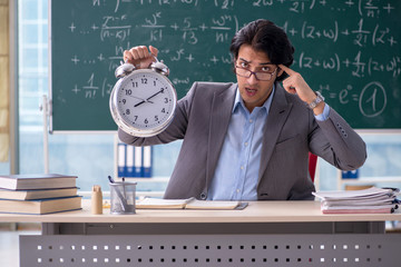 Young handsome math teacher in classroom