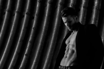 Muscular young man with beard on dark tunnel urban background. Fashion portrait of brutal strong...