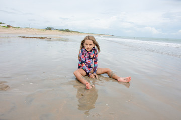 Menina criança brincando areia praia dia lindo