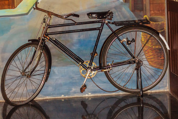 Naklejka na ściany i meble Vintage bicycle leaning to the wall. Old rusty bicycle in the country. Antique bike collection in the museum.