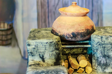 Vintage local kitchen area with old porcelain pot on the antique stove and firewood
