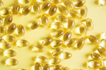 shiny yellow vitamin e fish oil capsule isolated on white background