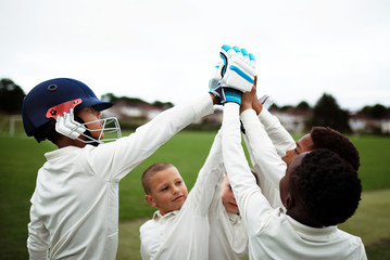 Group of young cricketers doing a high five