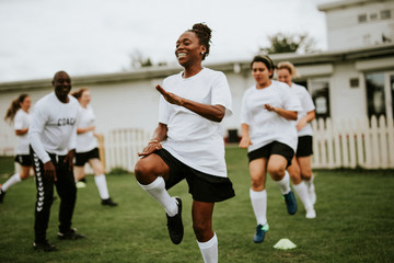 Female football players warming up on the field