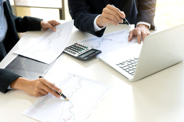 business man and woman sit at ther table looking at computer laptop