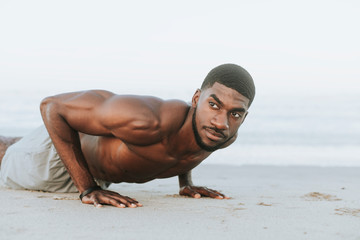 Fit man doing pushups in the sand