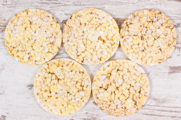 Puffed rice or corn waffles on old rustic board, healthy nutrition concept
