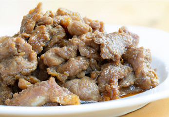Stir fry pork slice with sugar (Sweet pork) in white dish on wooden table, delicious Thai food Asia food