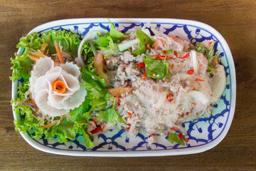 Vermicelli salad or Yum vermicelli with minced pork. Serve  in dish put on wooden table.