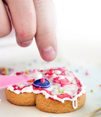 Kid hand decorating valentine cookie with copy space for text.