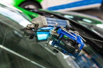man using repairing equipment to fix damaged cracked windshield