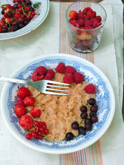 Bowl of oatmeal porridge with fresh strawberries and raspberries.Healthy breakfast. Flat lay, top view, copy space. Morning healthy breakfast.Close up. Healthy food, healthy breakfast concept.
