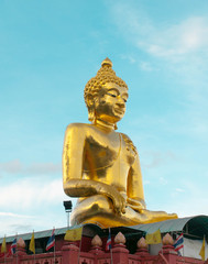 Giant Golden Buddha statue with blue sky Northern Thailand Chairai Province