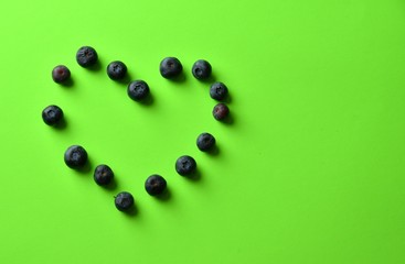 blueberry heart on green background