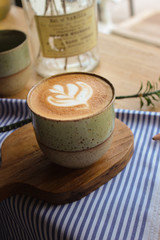 Latte coffee mug placed on a wooden table in a coffee shop
