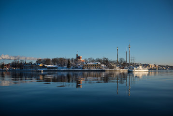 Fototapeta na wymiar A cold winter day in Stockholm with snow and ice on islands and boats