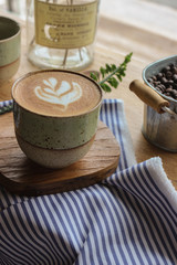 Latte coffee mug placed on a wooden table in a coffee shop