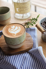 Latte coffee mug placed on a wooden table in a coffee shop