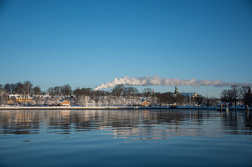 Fototapeta premium A cold winter day in Stockholm with snow and ice on islands and boats