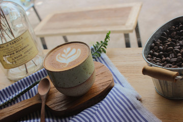 Obraz na płótnie Canvas Latte coffee mug placed on a wooden table in a coffee shop