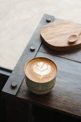 Latte coffee mug placed on a wooden table in a coffee shop