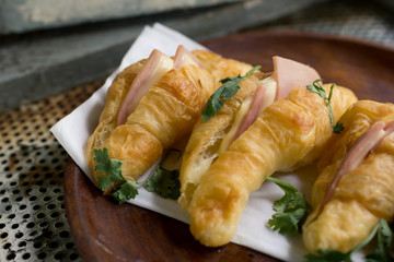 Croissant cheese in wooden dish placed on a rusty grill