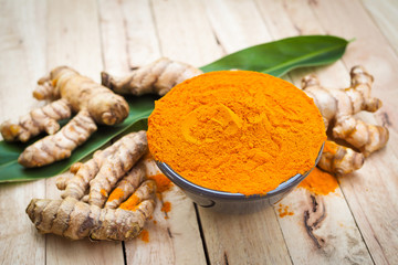 Turmeric powder in black bowls on old wooden table. herbal