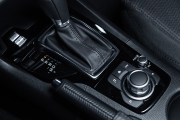 Сlose-up of the car  black interior:  dashboard,  accelerator handle, parking systems, seats and...