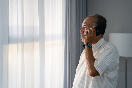 senior asian man calling with smartphone at home