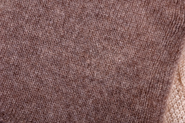 Texture of brown and beige knitted wool. Small knitting. Top view close up
