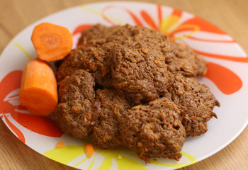 carrot cookies on plate with raw carrot pieces